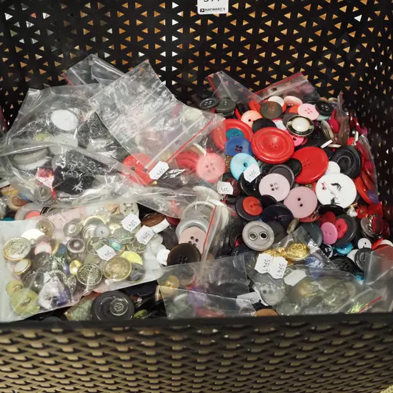 large plastic tub of numerous buttons