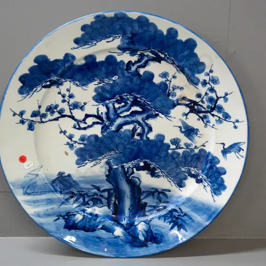 large blue & white asian tree scene wall charger with character mark on back. Some glaze or firing faults and bubbles