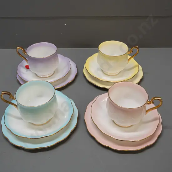 4 Royal Albert "Rainbow" trios in various colours, with gilt handles and rims