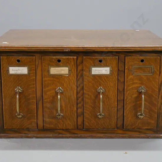 vintage oak desktop filing cabinet with 4 vertical drawers with brass handles and label holders -