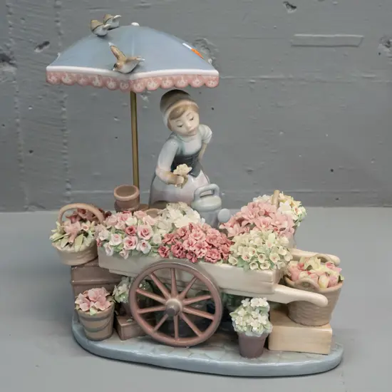 intricate Lladro figure of flower seller with cart and basket of flowers, birds etc. H-265 W-250.
