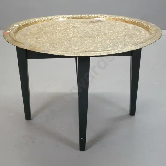 Persian style animal motif brass circular tray on ebonised timber table base - some discolouration and denting / bending