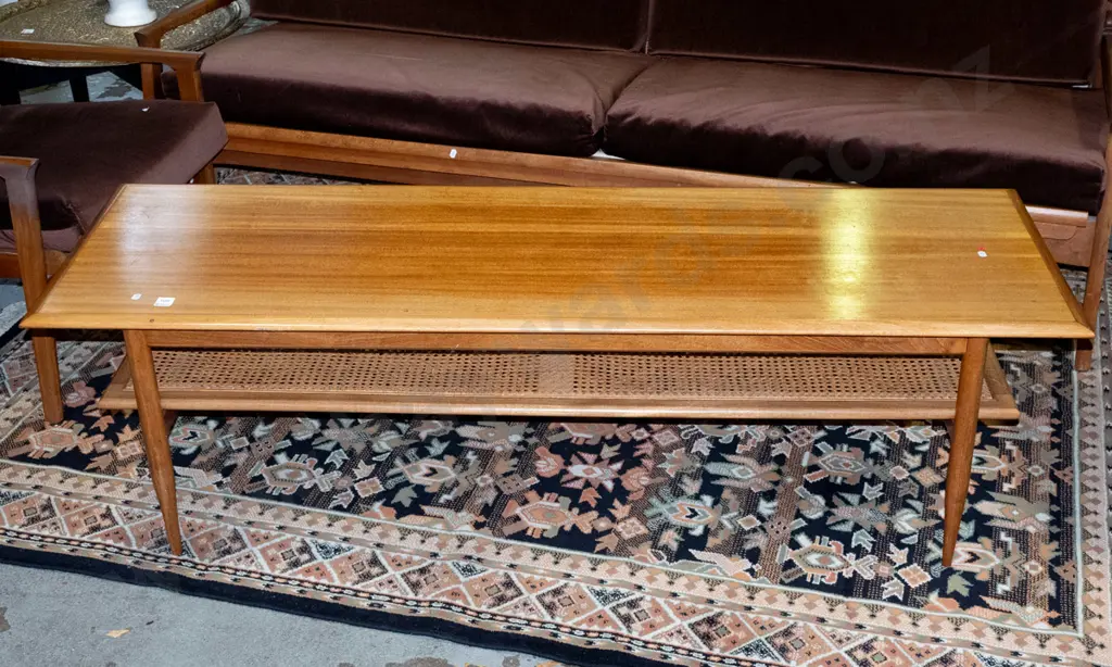 retro mahogany coffee table on turned legs, with cane inset magazine shelf, cross-banded edges. Loose leg joints, fading Image 1++