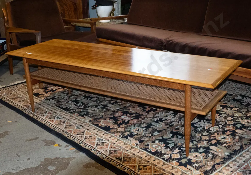 retro mahogany coffee table on turned legs, with cane inset magazine shelf, cross-banded edges. Loose leg joints, fading Image 1++