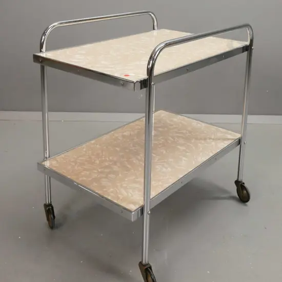 art deco tea trolley with 2 formica shelves on chrome frame on metal casters with rubber rims. Some corrosion to casters