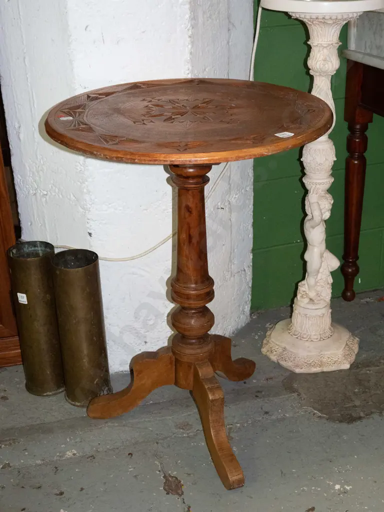 kauri and rimu wine table with geometric-carved circular top on turned column on 3 sweeping legs. Some staining, one leg Image 1++