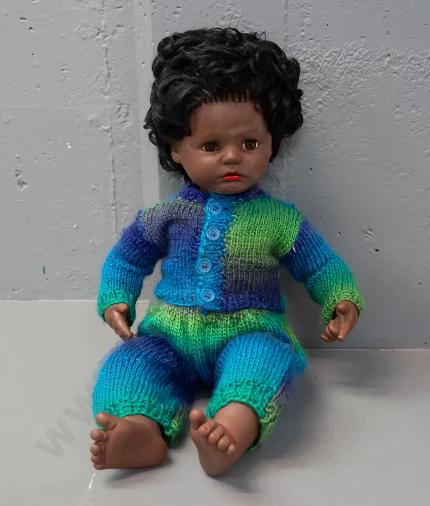 retro plastic doll with open and shut eyes, knitted outfit, back of head has logo with turtle in diamond shape, no Image 1++