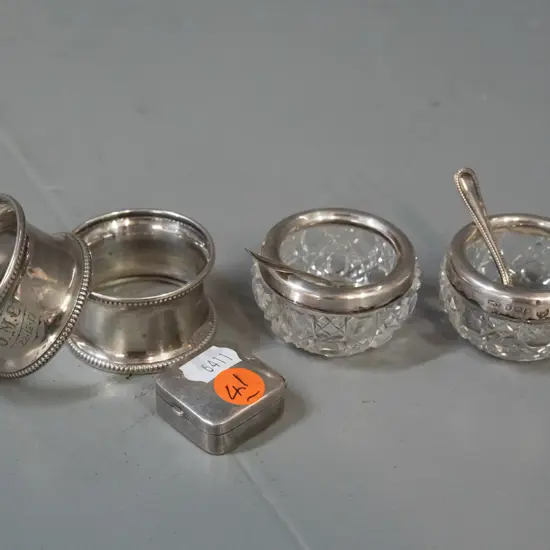 group of assorted sterling silver items - 2 napkin rings with 1917 inscriptions, small pill box and 2 cut glass salts