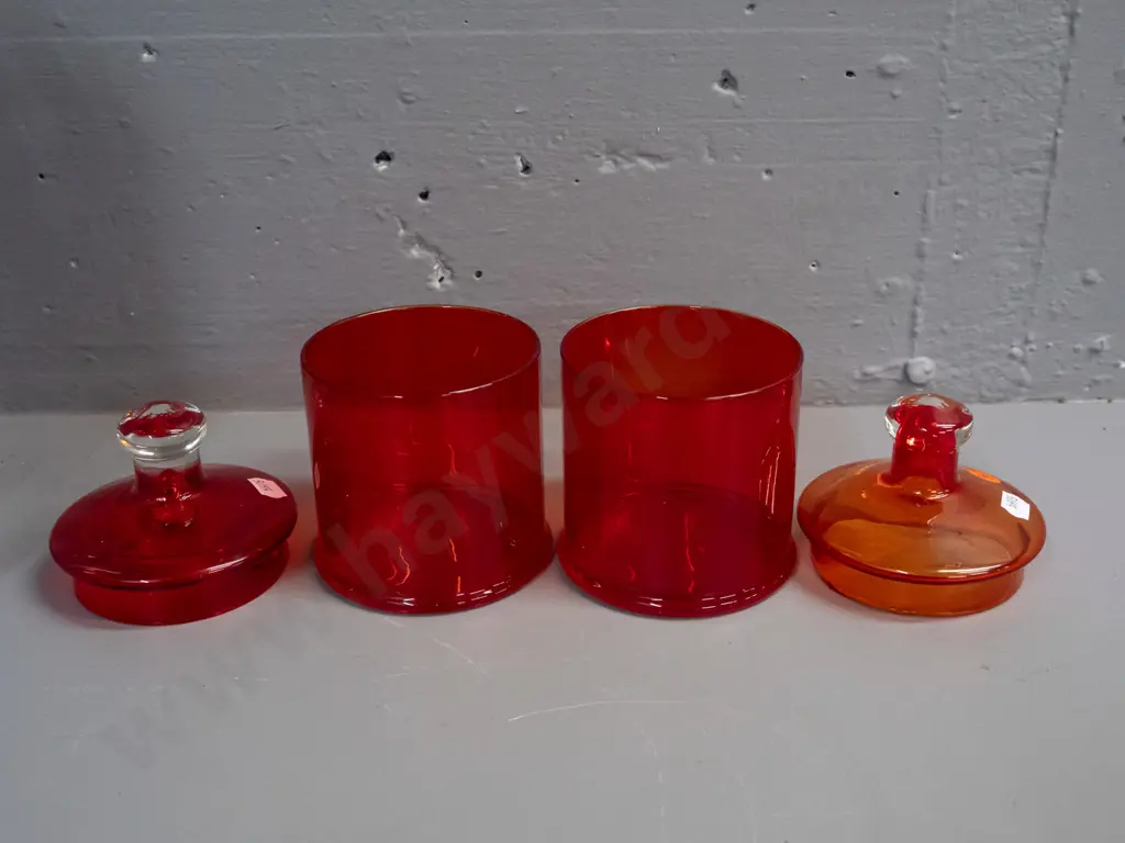 3 glass items - 2 red lidded canisters, one with clear knob, and a blue mottled art glass tall vase or jug with pouring Image 1++