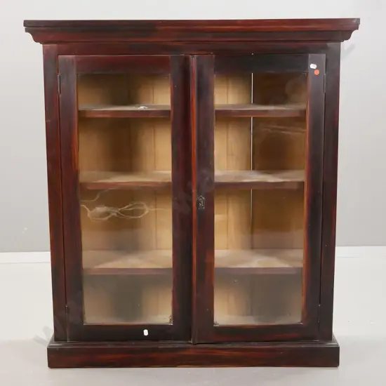 Edwardian dark stained rimu glazed book-case with 3 adjustable shelves, top over shaped moulded edge has slight bow,