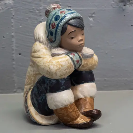 Lladro seated boy in inuit style clothing, marked 1985 on base H-170