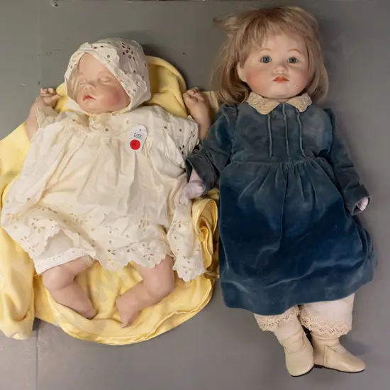 2 porcelain dolls, both by Pauline Lewis - girl marked Paris & sleeping infant with blanket marked 1988 - clothing on