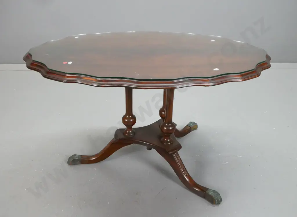 reproduction mahogany veneered serpentine shaped side table on 3 point base w/carved legs on brass lions paw Image 1++