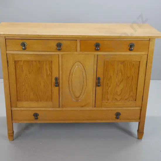 vintage oak sideboard with 2 top drawers, one long bottom drawer, 2 doors, metal drop handles, panelled sides, one