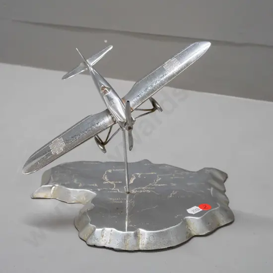 cast metal aeroplane model on heavy roughly cast base in shape of map of Lithuania, engraved with place names. Aeroplane