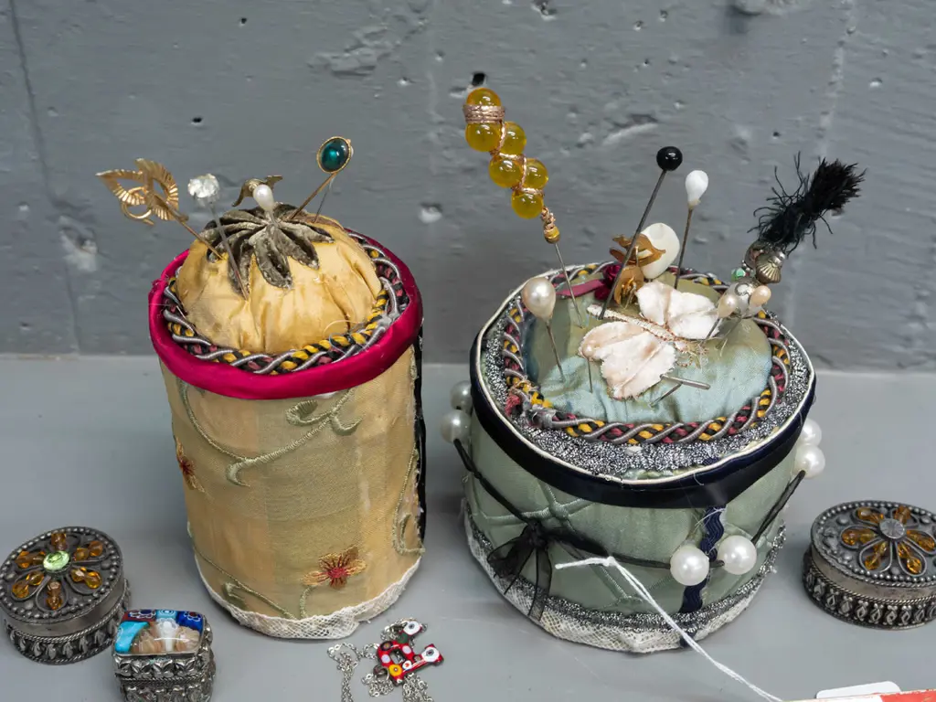 2 cylindrical fabric-covered pin cushions with assorted hat and lapel pins, Japanese timber and paper fan, millefiore Image 1++