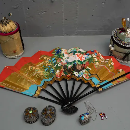 2 cylindrical fabric-covered pin cushions with assorted hat and lapel pins, Japanese timber and paper fan, millefiore