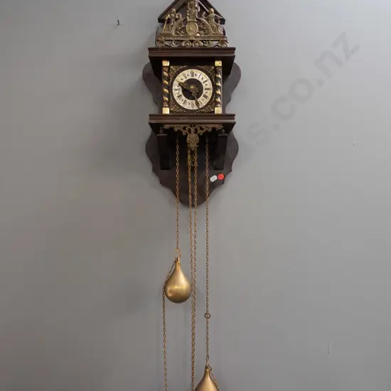 reproduction Dutch wall clock with cast metal pendulum and ornaments, pear-shaped weights, atlas figure & cast motto