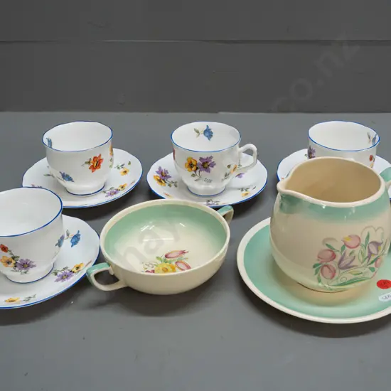 3 pieces Susie Cooper and 4 vintage Royal Albert cups & saucers with floral decoration and blue rims. Susie Cooper jug