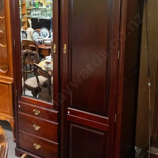 reproduction mahogany wardrobe in the style of a linen press with 2 doors, 1 w/bevelled edge mirror, 3 drawers, brass