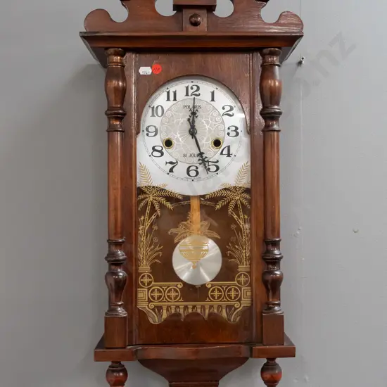 reproduction Polaris wall clock in walnut cabinet with gilt-decorated glazed door, half-turned supports, bottom finials