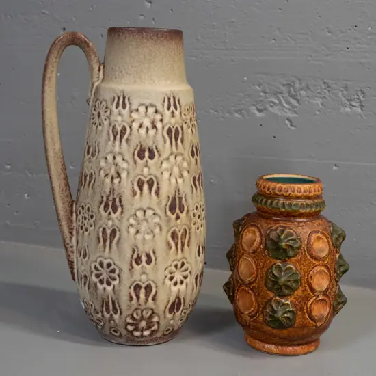 2 German pottery vases with embossed decoration - large handled jug vase has small glaze faults, one at bottom rim and