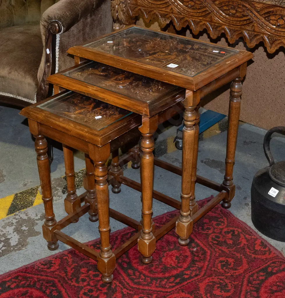 asian set of 3 nesting tables with carved scenic tops covered with inset glass panels with turned supports and stretcher Image 1++
