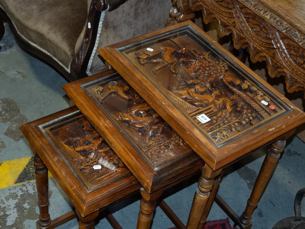 asian set of 3 nesting tables with carved scenic tops covered with inset glass panels with turned supports and stretcher Image 1++