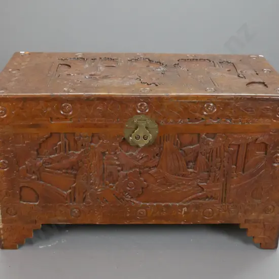 Chinese camphorwood chest with profusely carved scenic panels, tray inside, brass split-key lock, scallop shape