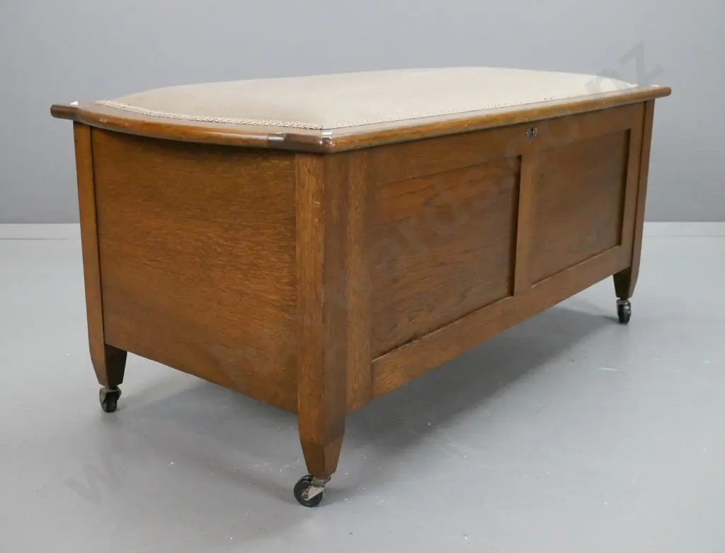 Art deco oak blanket box, with upholstered top, 2 panel front on castors, lock is broken Image 1++