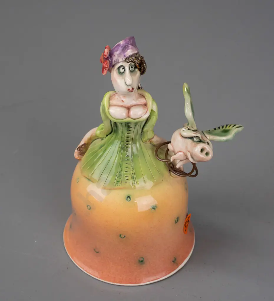 Marion Mewburn - ceramic figurine in the form of a bell w/ legs suspended inside dress, with flying pig attached on wire Image 1++
