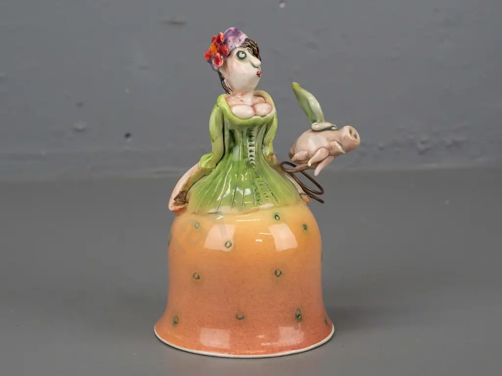 Marion Mewburn - ceramic figurine in the form of a bell w/ legs suspended inside dress, with flying pig attached on wire Image 1++