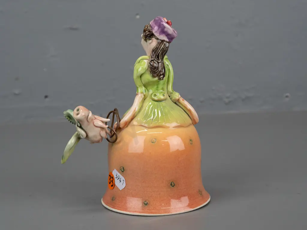Marion Mewburn - ceramic figurine in the form of a bell w/ legs suspended inside dress, with flying pig attached on wire Image 1++