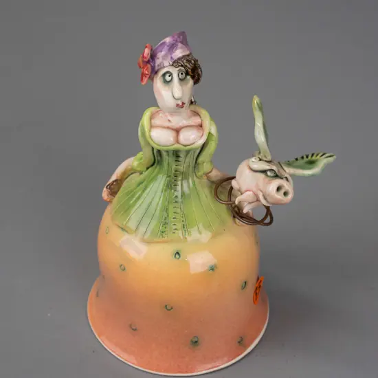Marion Mewburn - ceramic figurine in the form of a bell w/ legs suspended inside dress, with flying pig attached on wire