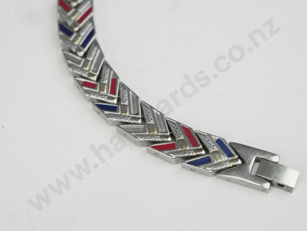 Silver bracelet, links in a chevron pattern. Some links are gold, blue and red. Image 1++