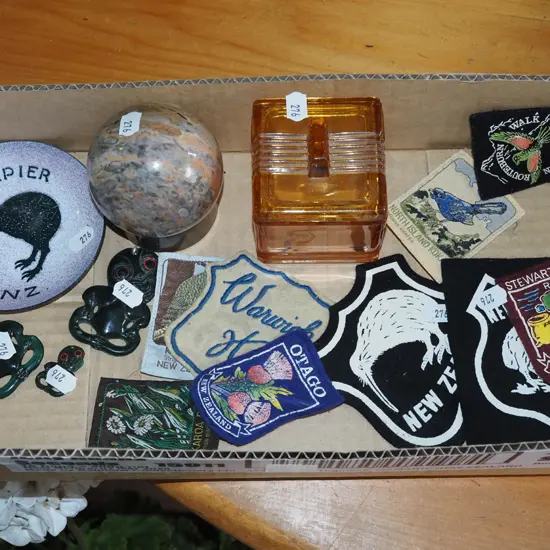 box; plastic tikis, enamel ashtray, NZ badges etc