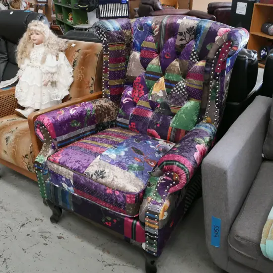 brightly patchwork style upholstered wingback armchair with cab legs and silver dome finish