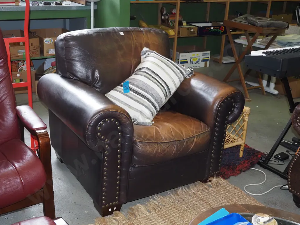 brown leather rolled arm armchair with dome studding on front - some wear to leather Image 1++
