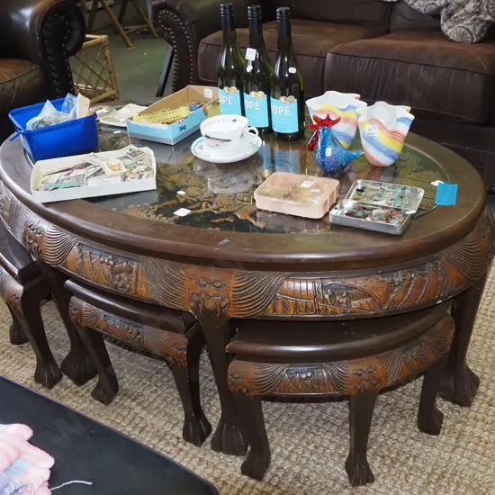 Chinese low oval dining table, heavily carved battle scene under glass with 6 matching pull out stools H500 W1250 D780