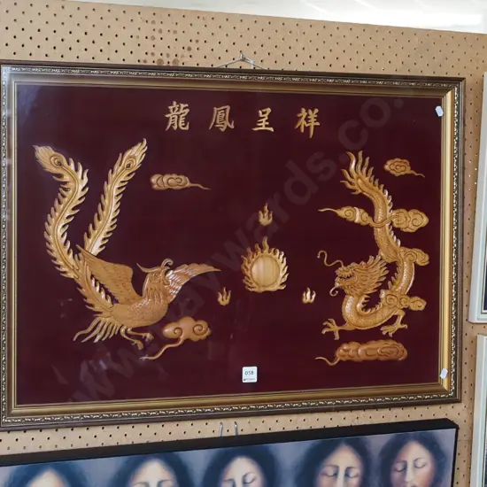 carved Asian phoenix and dragon scene behind glass