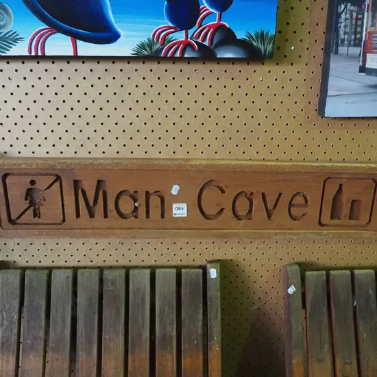 carved wooden man cave sign