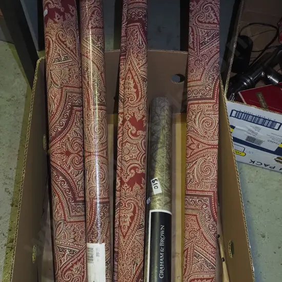 box of various rolls of patterned wallpaper