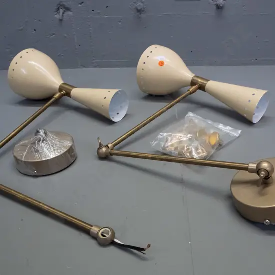 pair of reproduction mid-century style alloy wall-mount bedside lamps with adjustable angle arms, painted pierced shades