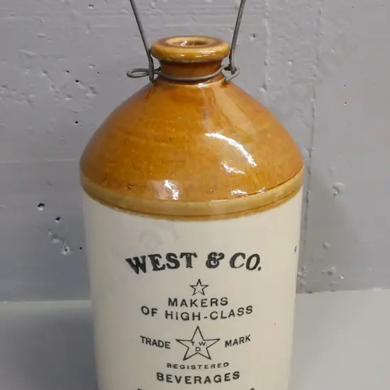 Stonewear crock marked Timaru for West & Co Beverages Dunedin. With wire handle, missing stopper. H-330 D-160