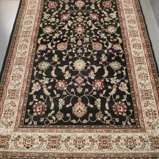 "Nazreen" Indonesian machine woven floor rug in black, red and browns, foliate motifs L-2900 W-2000