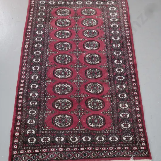 Pakistani hand-knotted wool Turkoman style floor rug in dark reds, black and ivory - some wear & spots of loss to pile.