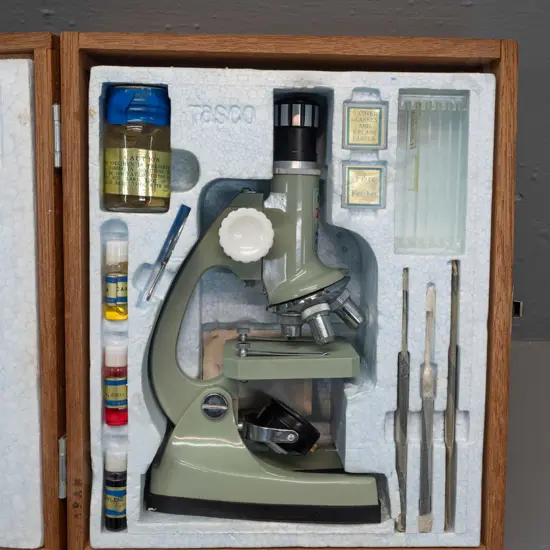 1960s Tasco Zoom 900x microscope set in hinged wooden case, with dyes, crab specimen, tweezers, slides & booklet. Case