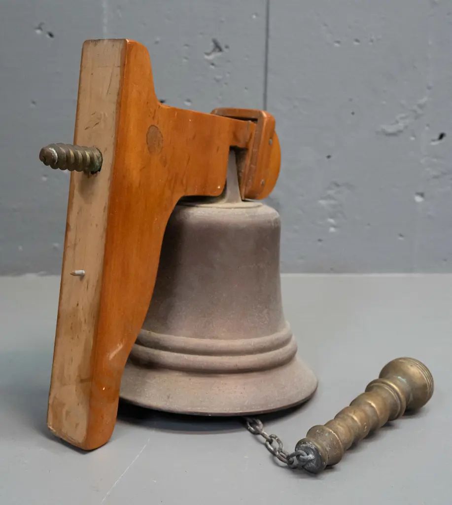 Cast metal wall-mount school bell w/ wooden wall bracket heavy cast handle painted wolf logo. Bell H-140 D-145 [some age Image 1++