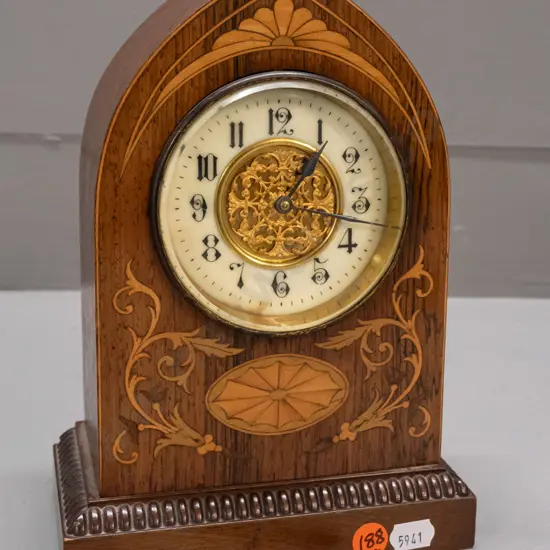 vintage mantel clock in arched rosewood case with boxwood and harewood stringing and inlays, porcelain face with pierced