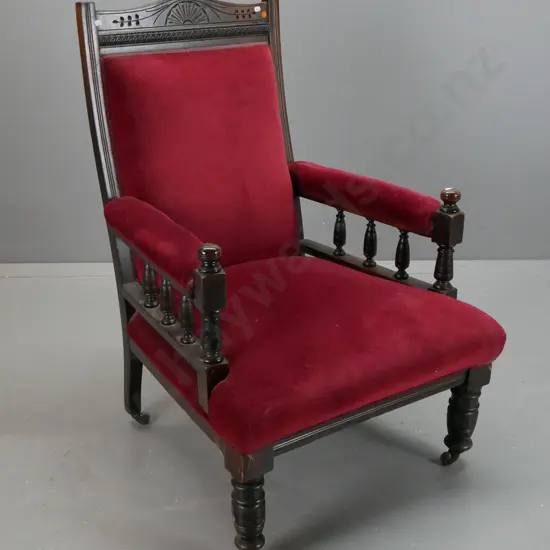 Edwardian beech open-arm armchair with shaped carved back, turned front legs and arm supports, porcelain casters -